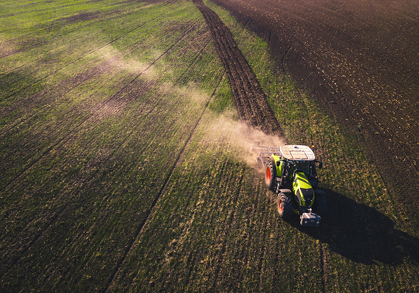 Ein Traktor fährt über einen Acker, der mit Effektiven Mikroorganismen behandelt wird.