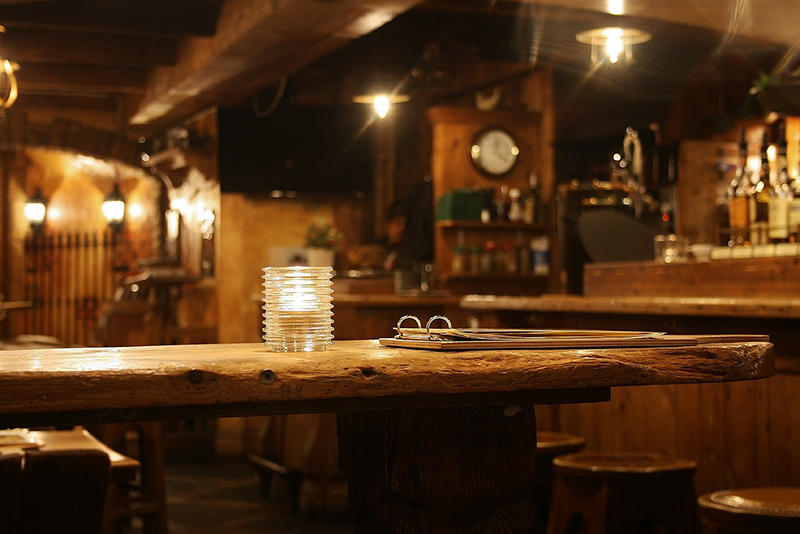 Eine Bar mit viel Holz in warmes Licht getaucht.