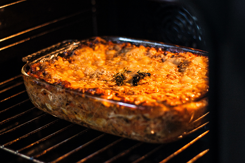 Ein Auflauf wird im Ofen in einer Auflaufform aus Glas gegart und mit Käse überbacken.
