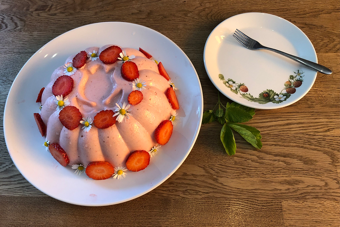 Die Bayerische Creme ist mit Erdbeeren und Gänseblümchen garniert.