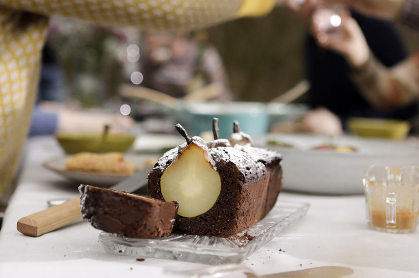 Der selbst gebackene Birnenkuchen steht auf einem gedeckten Tisch.