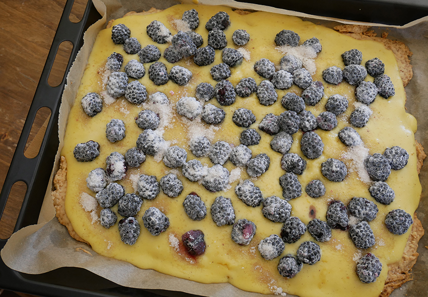 Der Kuchen ist mit einer Vanillecreme und Brombeeren belegt.