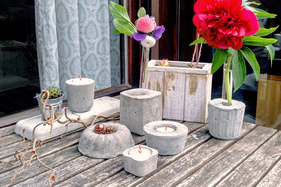 Vom Blumentopf bis zur Vase und Kerzenhalter sind mögliche Deko-Formen auf dem Balkontisch versammelt.