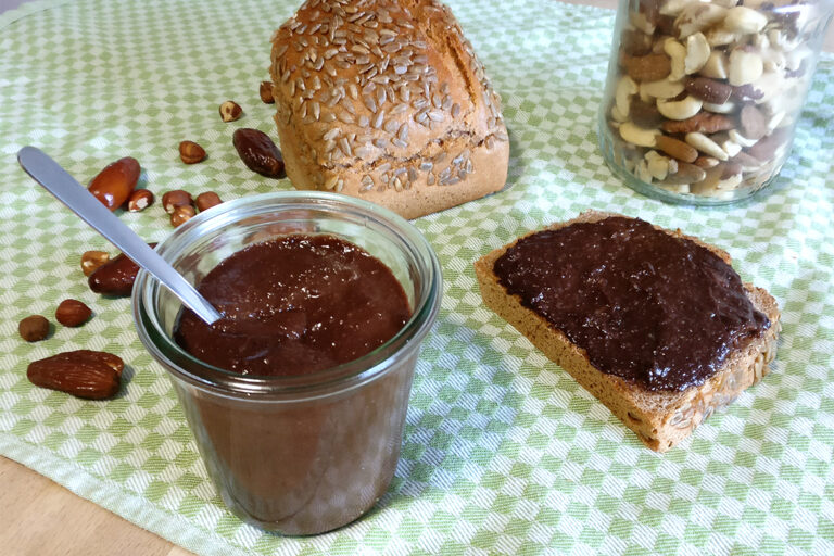 Die dunkle Nuss-Nougat-Creme ist im Weckglas und auf dem Brot zu sehen.