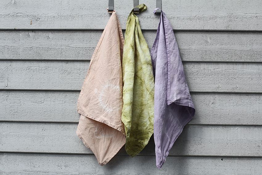 Drie bonte linnen doeken gebatikt met plantaardige kleurstoffen.