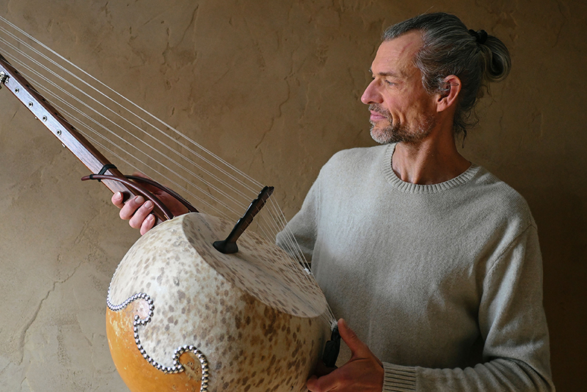Frank Heinkel hält eines seiner Naturinstrumente, eine N'Goni, in den Händen.