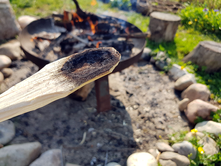 In den grob geschnitzten Löffel wird mit einem Stückchen Glut eine Vertiefung hineingebrannt.