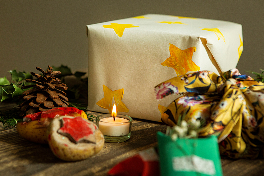 Mehrere Geschenke sind nachhaltig verpackt und liegen auf einem Holztisch bereit.