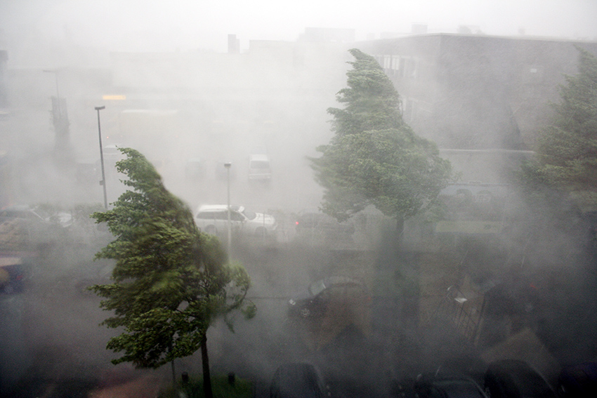 Starker Wind peitscht Regen durch eine Straße.