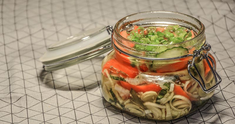 Das offene Einmachglas ist mit eingelegtem Gemüse gefüllt.