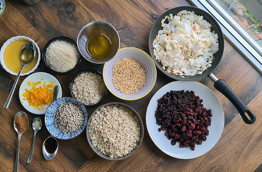 De ingrediënten voor de zelfgemaakte kokos granola zijn afgewogen en staan klaar op het werkblad.
