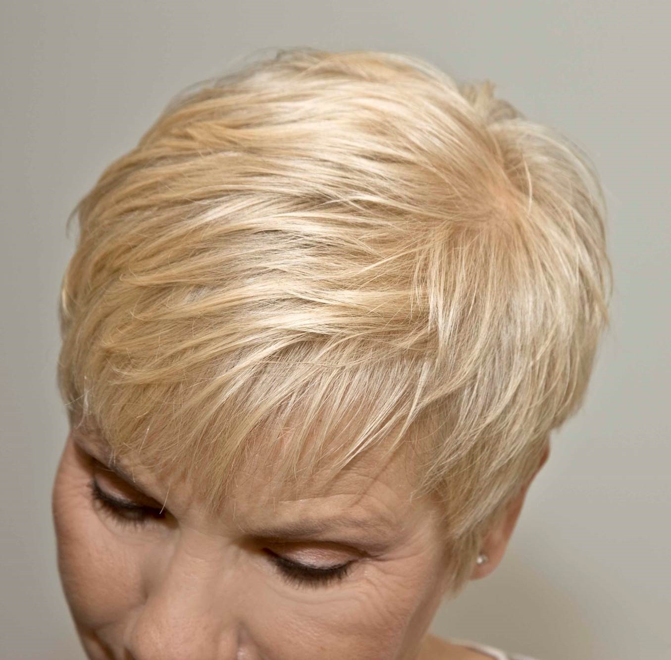 Nach der Behandlung mit Naturhaarfarbe hat die Frau natürlich leuchtendes blondes Haar.