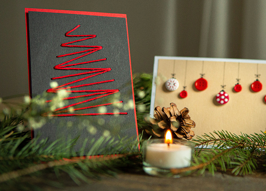 Auf die DIY-Weihnachtskarte wurde mit einem roten Faden ein Tannenbaum gestickt.