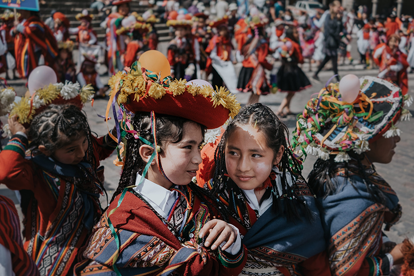 Peruanische Mädchen in bunten Klamotten sind auf einem Volksfest.