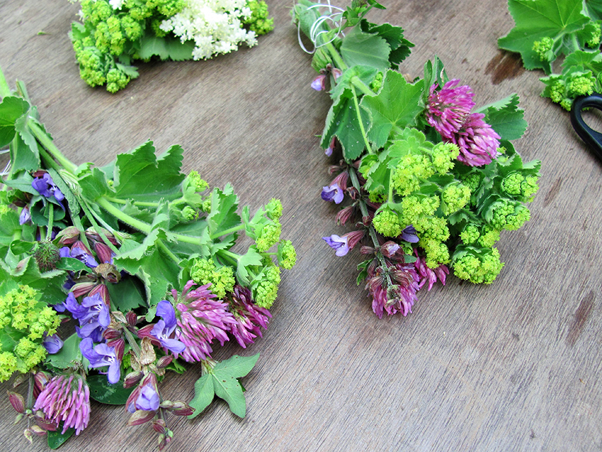 Verschiedne Sträußchen mit Blüten und Blättern liegen nebeneinander.