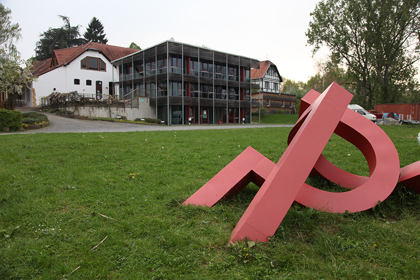 Ein rotes Kunstwerk steht auf dem Kampus der Alanus-Hochschule.