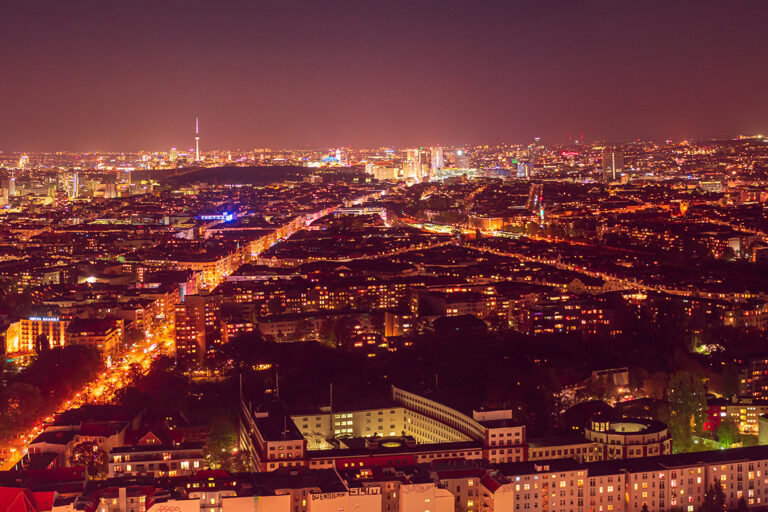 Eine Stadt erhellt durch die vielen Lichter den Nachthimmel und trägt zur Lichtverschmutzung bei.