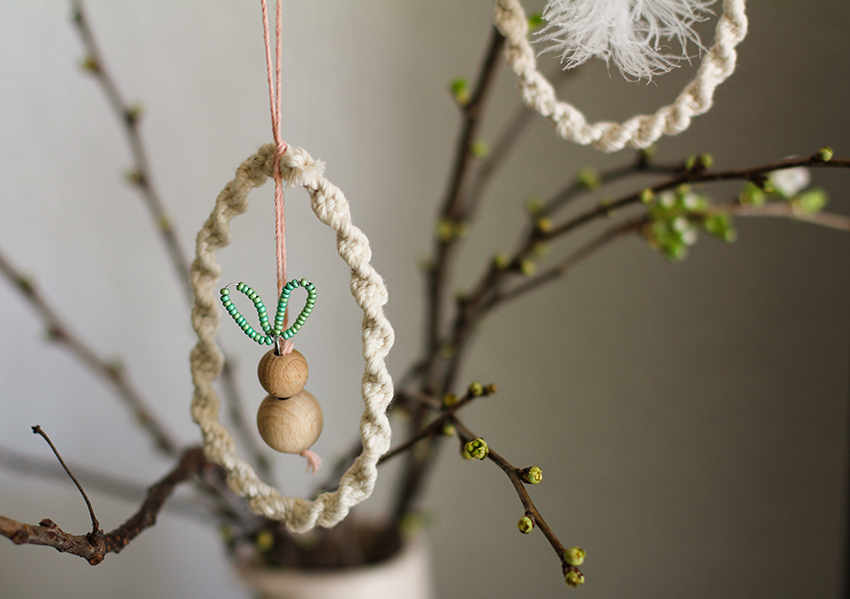 Das Innere der gebastelten Makramee-Osterdeko ziert ein kleiner Hase aus Holzperlen.