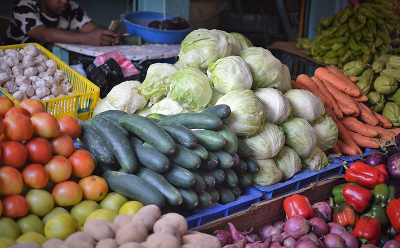 Een marktkraam met sla, komkommers, wortelen...
