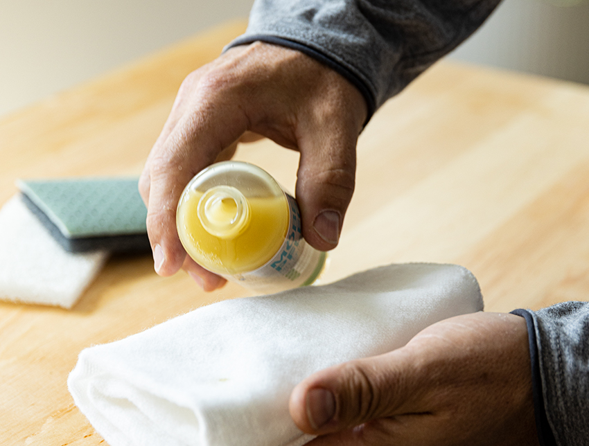 Een meubelpolish wordt op een witte doek aangebracht om de houten meubels te verzorgen.