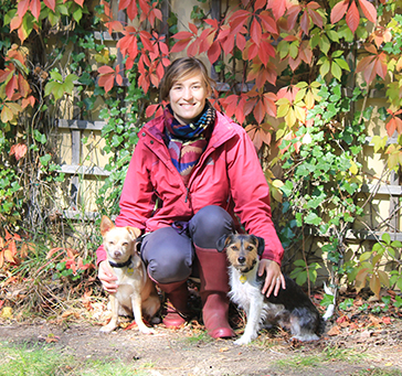 Friedlich sitzen die beiden Hunde naben der Hundepsychologin in der Sonne