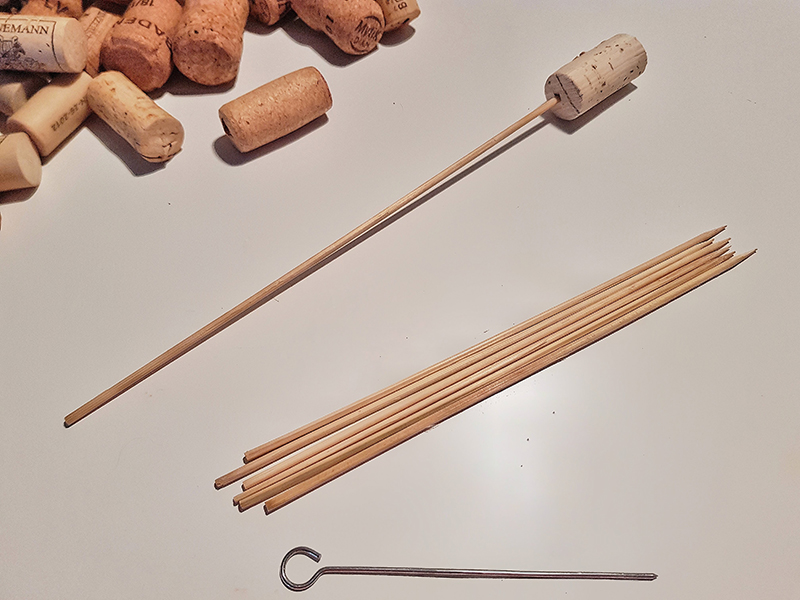 Korken, Holzspieße und eine Rouladen-Nadel liegenbeisammen.