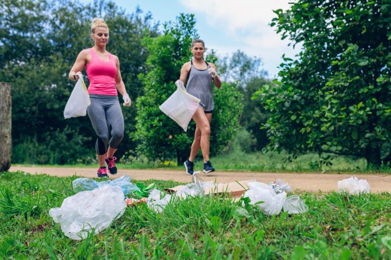 Zwei Frauen joggen mit weißen Mülltüten. Im Vordergrund liegt Müll.