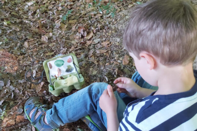 Fleißig ist der Junge bei der Schatzsuche in der Natur.