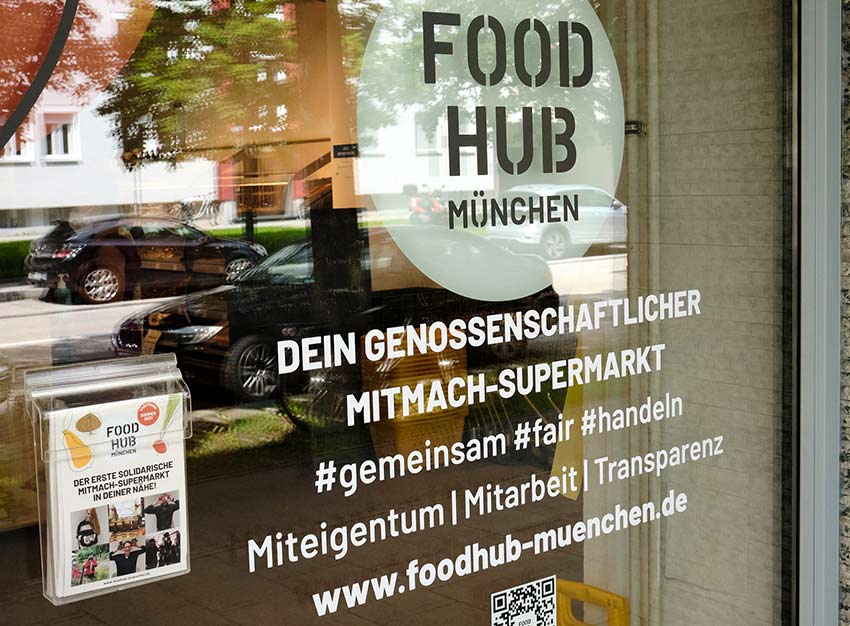 Am Schaufenster des Supermarktes sind die Prinzipien und Werte des Ladens aufgeklebt.