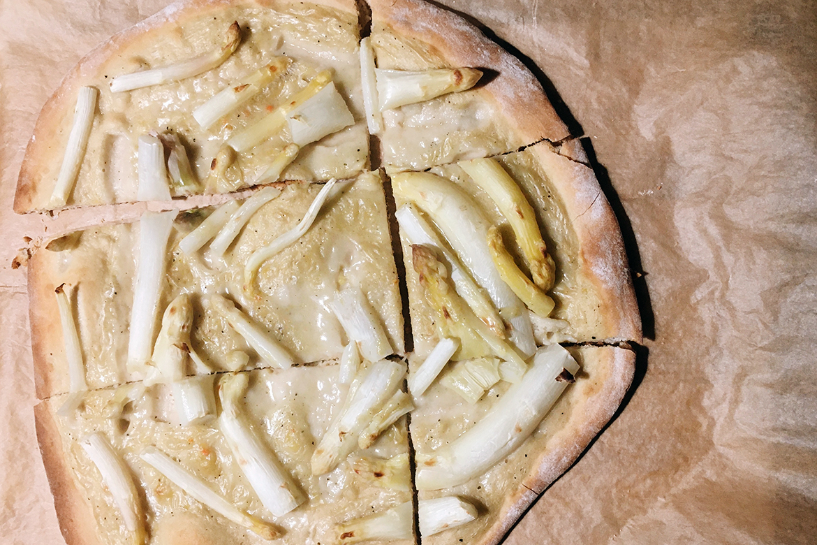 Die selbst gemachte Spargelpizza liegt auf einem ausgebreiteten Backpapier.