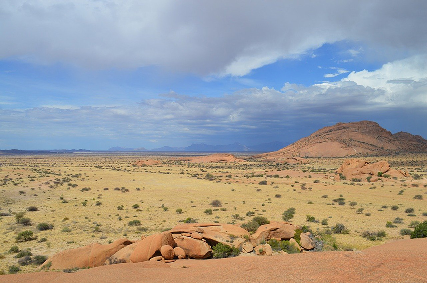 Blick in die Weite einer Steppenlandschaft mit viel Sand und Stein.