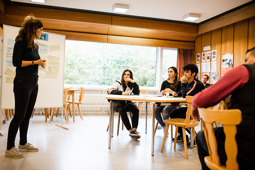 In kleinen Unterrichtsgruppen sitzen Schülerinnen und Schüler in einem Kurs der MUT Academy.