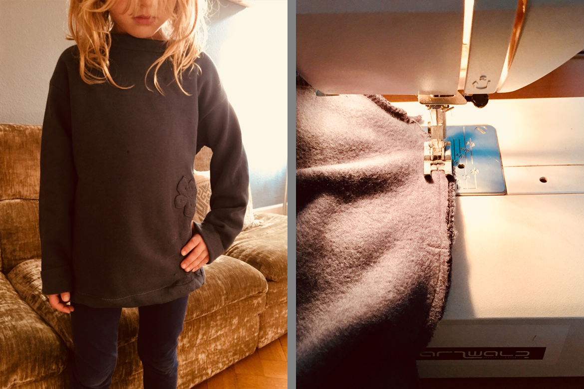 Ein kleines Mädchen trägt den Upcycling-Kinderpullover.