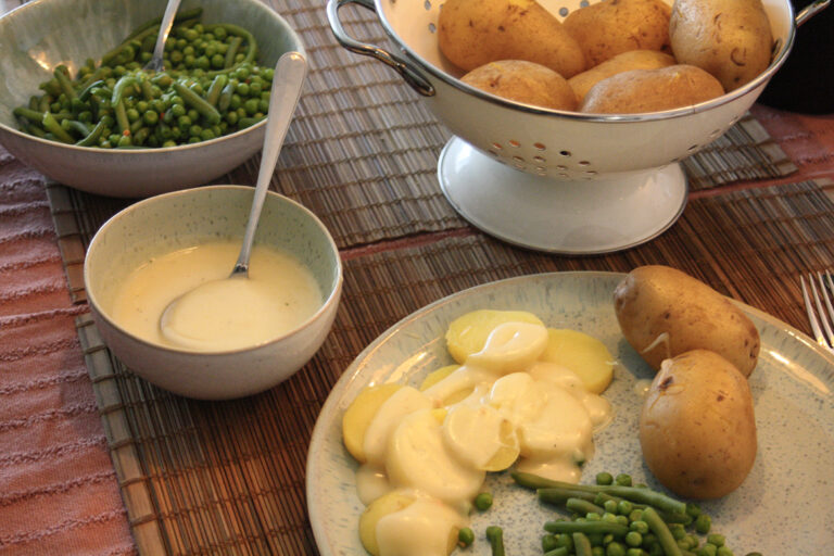 Die vegane Béchamelsauce wird mit Kartoffel und Erbsen und Bohnen serviert.