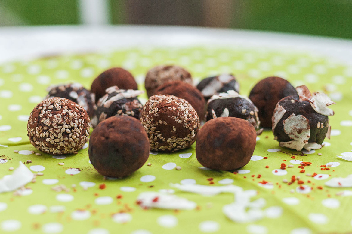 Drei Sorten vegane Pralinen liegen zum Verzehr bereit. Sie erinnern optisch an Trüffel.