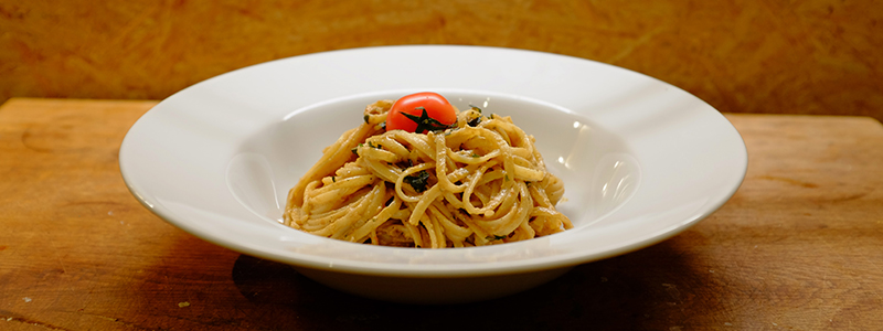 Ein Teller mit Pasta und Pesto steht bereit zum Verzehr.