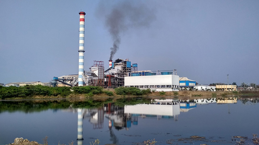 Een industriële fabriek met op de voorgrond een watervlakte..