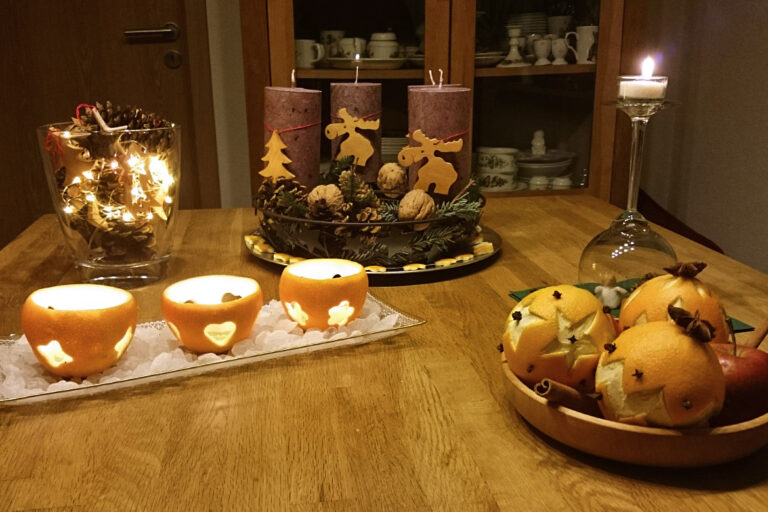 Weihnachtliche Tischdeko aus Orangen und Tannenzapfen