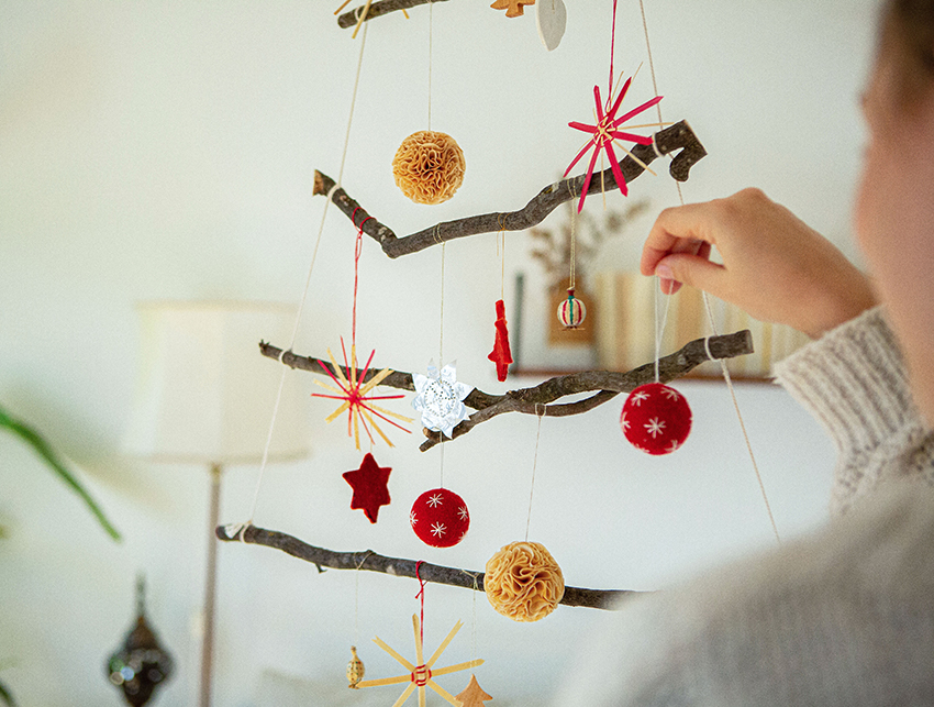 Der Weihnachtsbaum aus Ästen wird geschmückt.