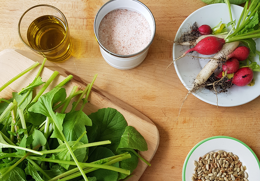 Einige Zutaten für das Radieschen-Pesto sind auf einem Esstisch bereitgestellt.