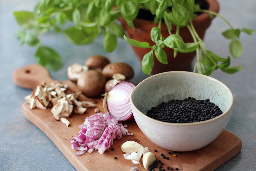 De veganistische linzenbolognese bestaat voornamelijk uit champignons, uien en zwarte linzen.