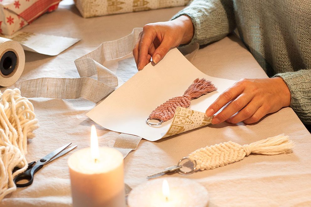 Ein Makramee-Schlüsselanhänger wird in Geschenkpapier verpackt.