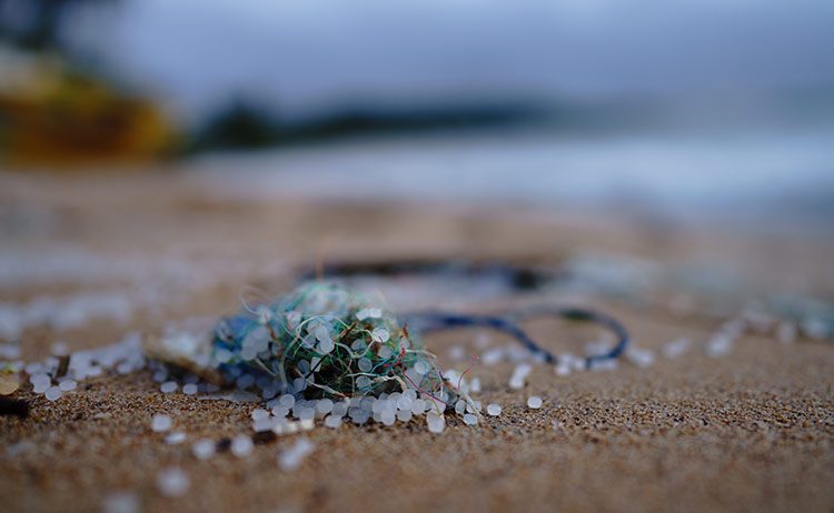 Microplastics verzamelen zich in het zand op dit strand en een deel van de vervuiling komt van microplastics in kleding.