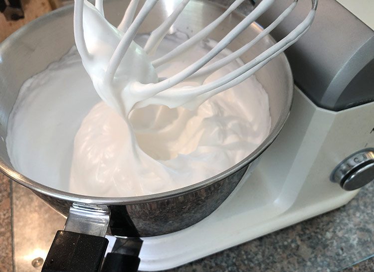 In einer Küchenmaschine wird Aquafaba zu einem luftigen, veganen Eischnee aufgeschlagen.