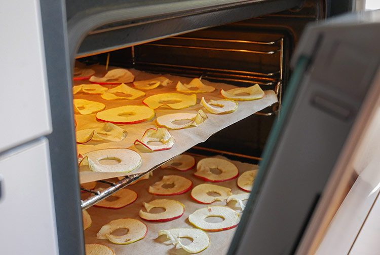 In de oven worden de appelringen uitgespreid op twee bakplaten.