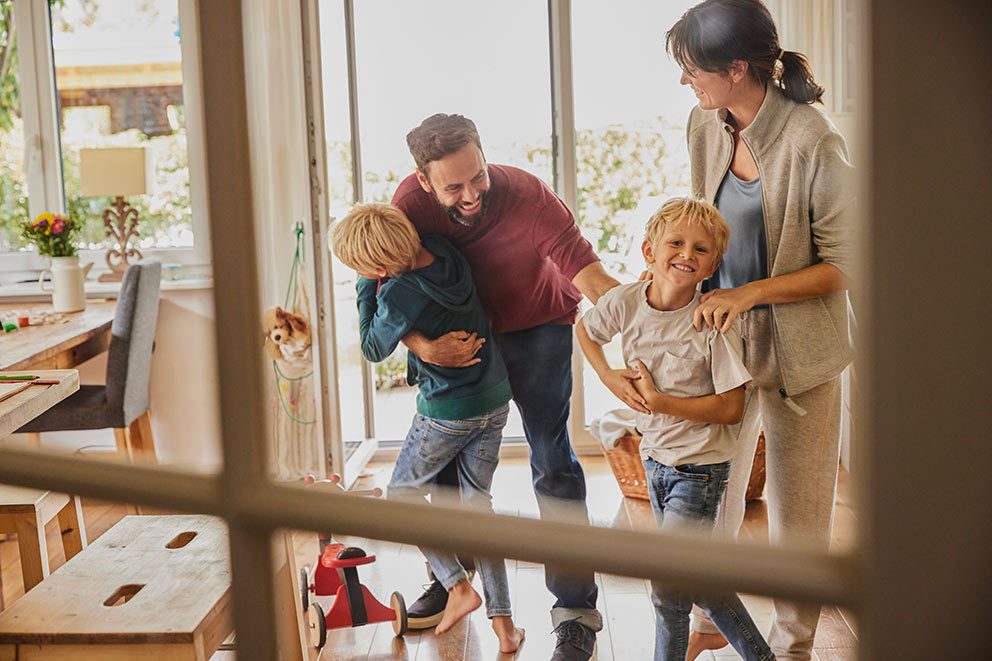 Der Vater kommt nach Hause und wird von seinen Söhnen und seiner Frau begrüßt.