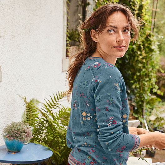 Frau in Bio-Pullover mit Jacquard-Muster im Garten