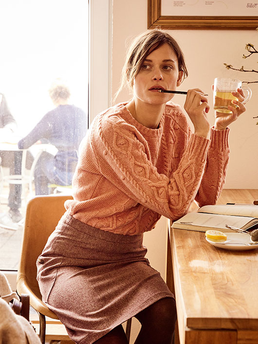Frau in einem Bio-Pullover in einem Cafe