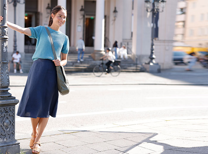 Frau in blauer Leinenkleidung bei einem Stadtbummel