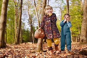 Mädchen und Junge in kuschliger Herbstmode aus Bio-Wollwalk im Wald